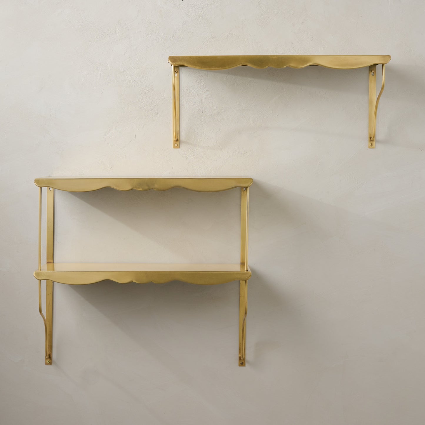 Rosalie Double Brass Scalloped Shelf shown on wall with single shelf