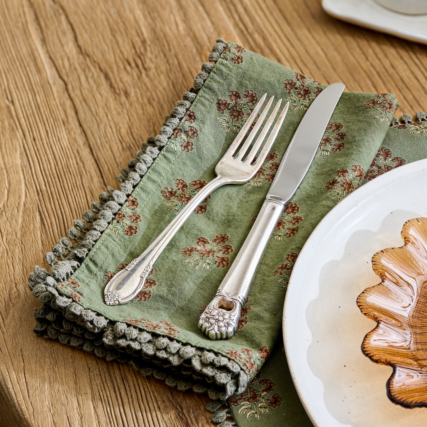Magnolia Olive Green Block Printed Napkin shown on table with silverware