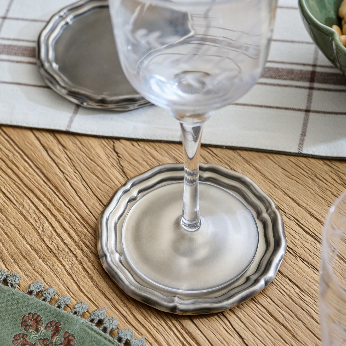 Vintage-Inspired Pewter Coaster Set shown under wine glass