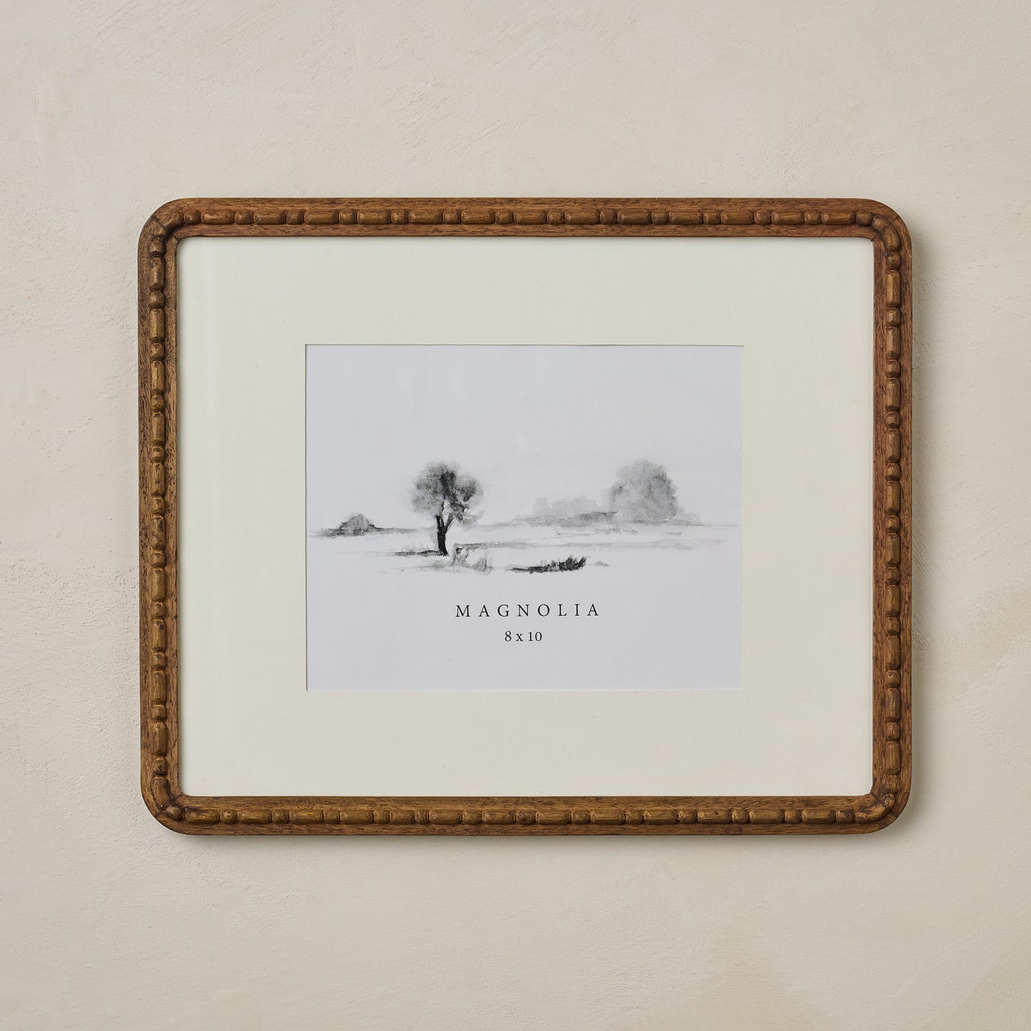Nicolette Carved Wood Photo Frame in size 8x10 hanging on beige wall
