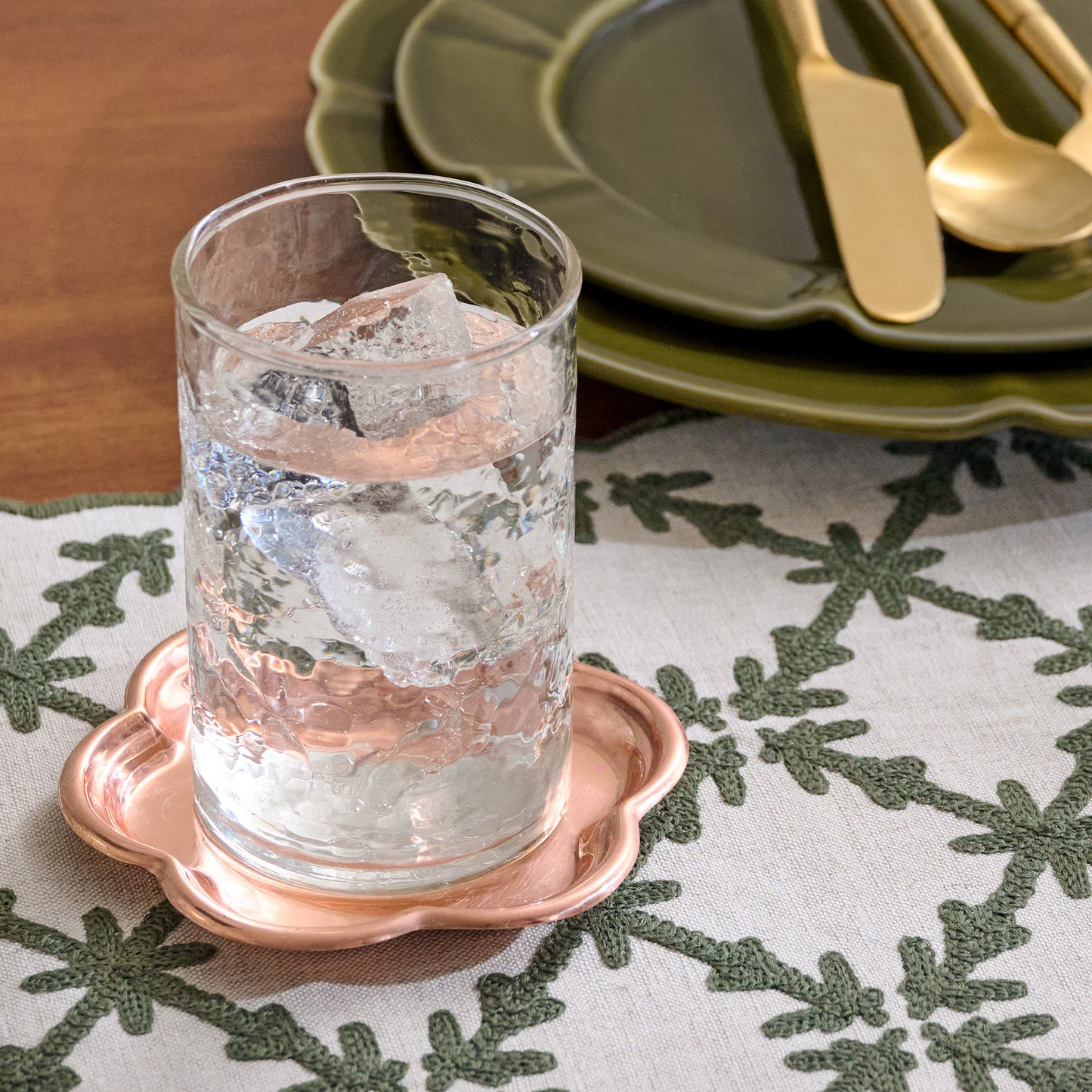 Antique Copper Scalloped Coaster shown with glass of water