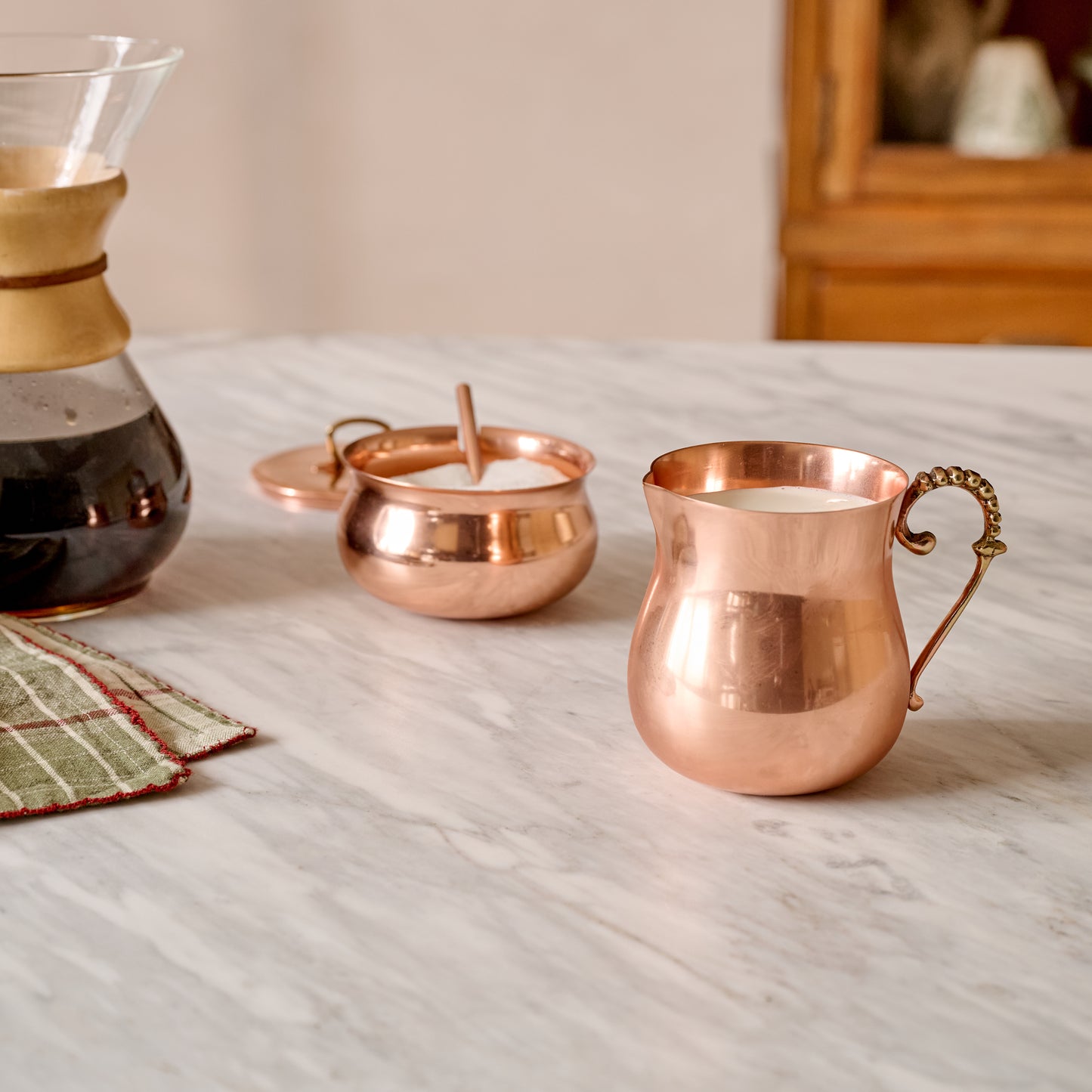 Antique Copper Creamer shown on counter with matching sugar canister