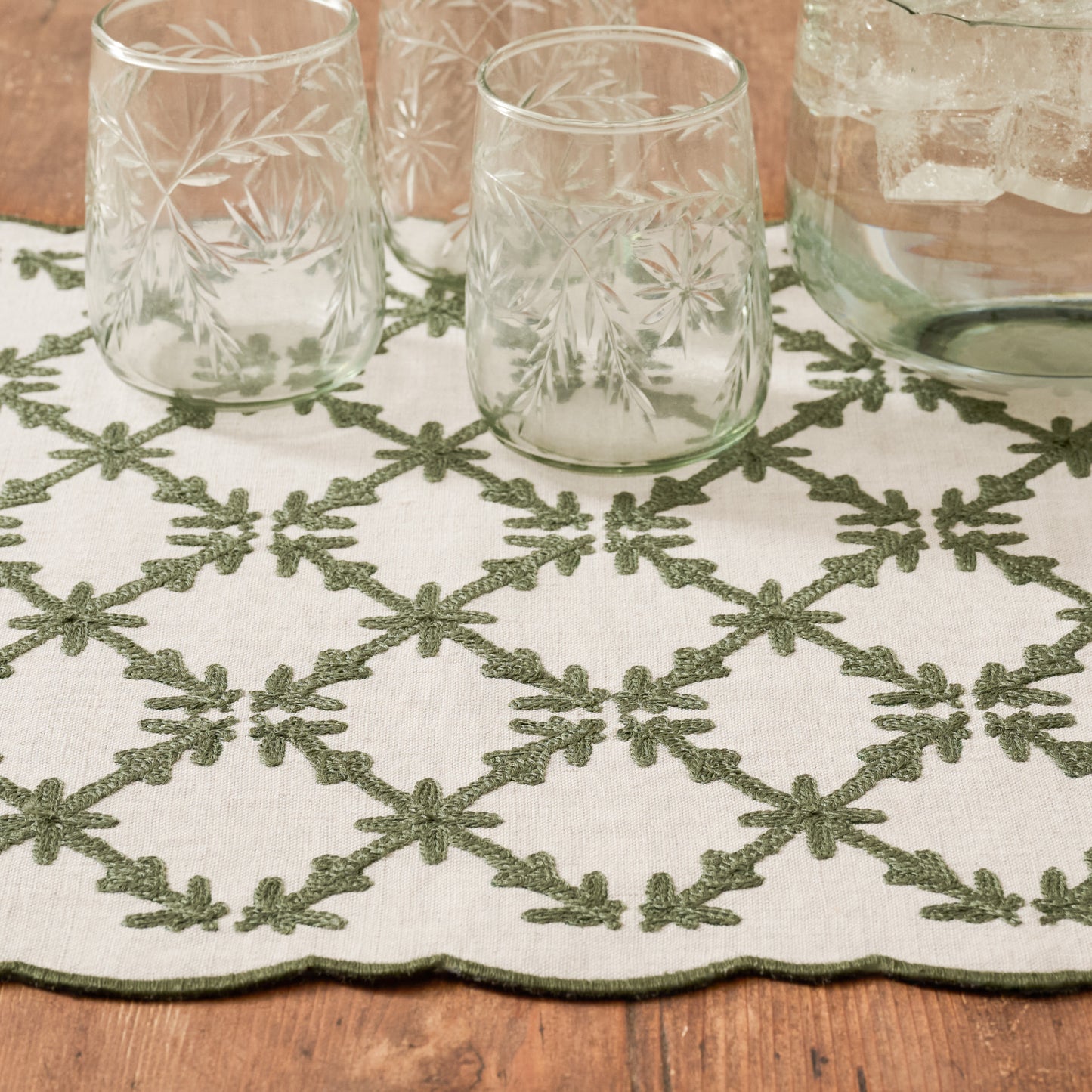 Moss Green Eleanor Embroidered Table Runner up close shown with etched glasses