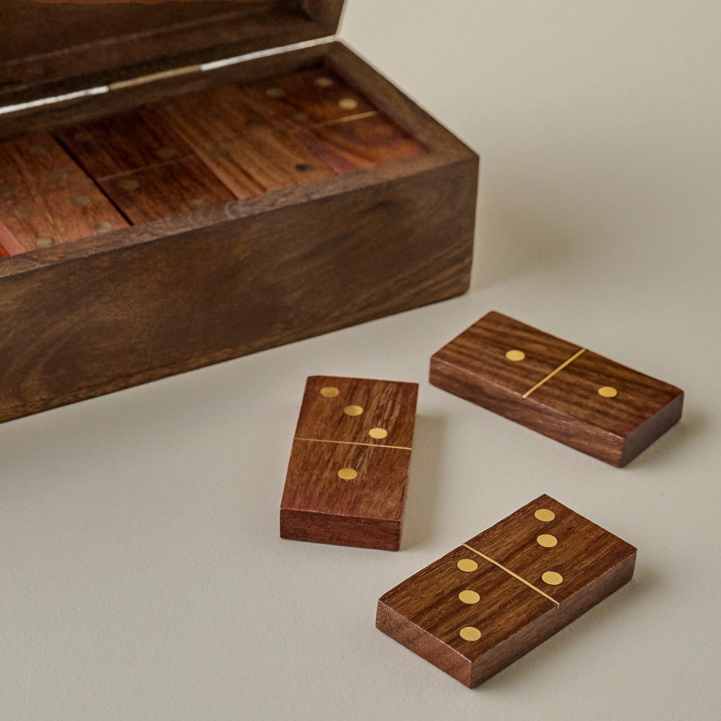 Wooden dominoes set with a wooden box on a light background