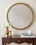 Julie Round Brass Scalloped Mirror in a room with brass vase with white daffodils and home fragrance