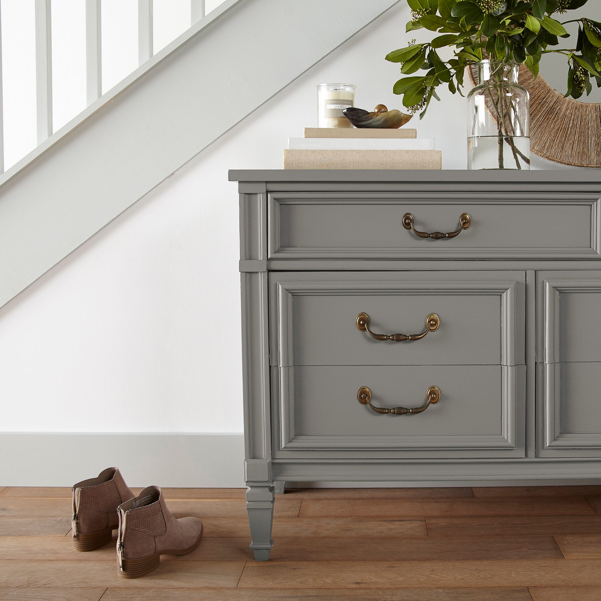 dark grey with olive-brown undertones paint named garden trowel shown painted on entryway cabinet