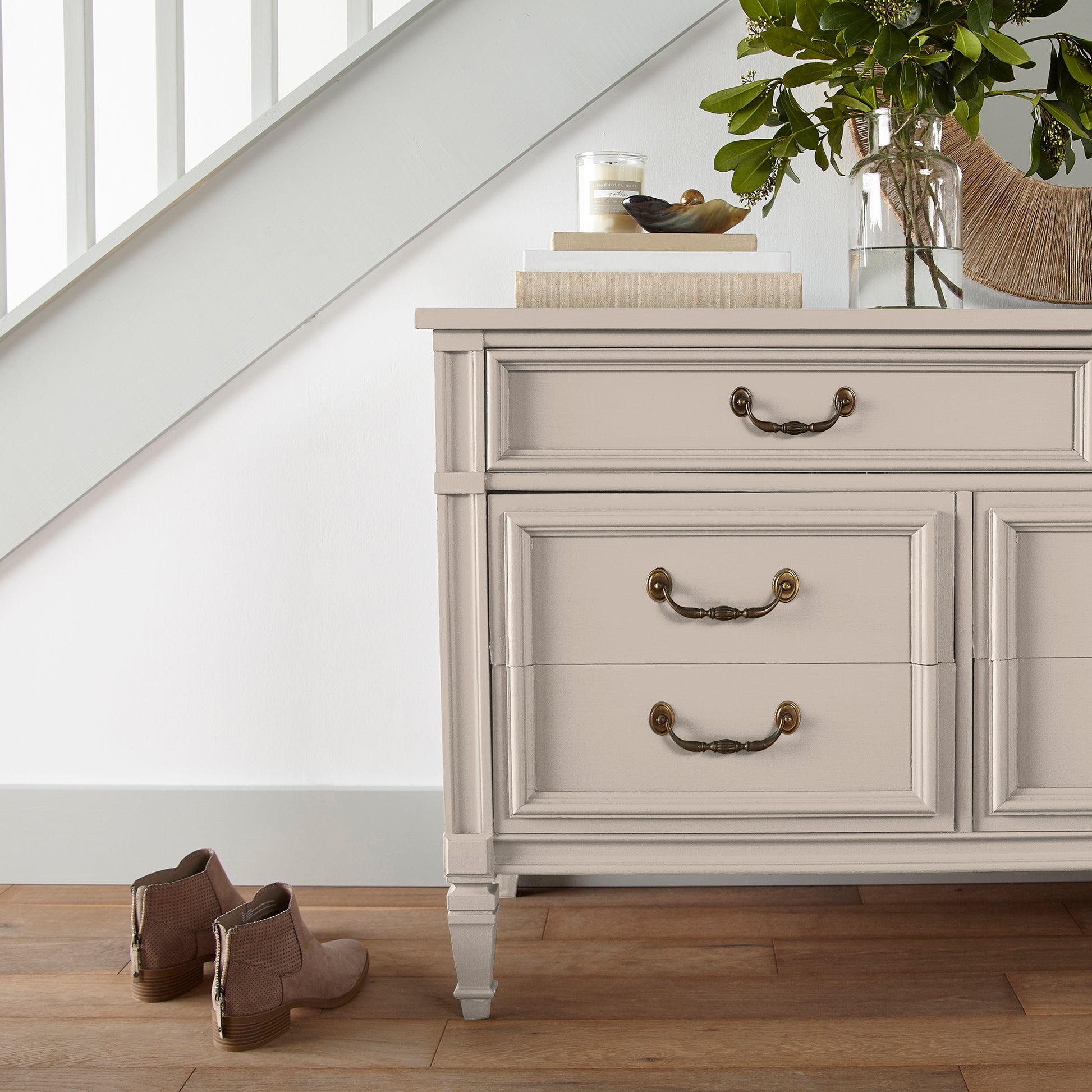 Warm soft peach trim, door and cabinetry paint named dutch tulip shown painted on entryway cabinet