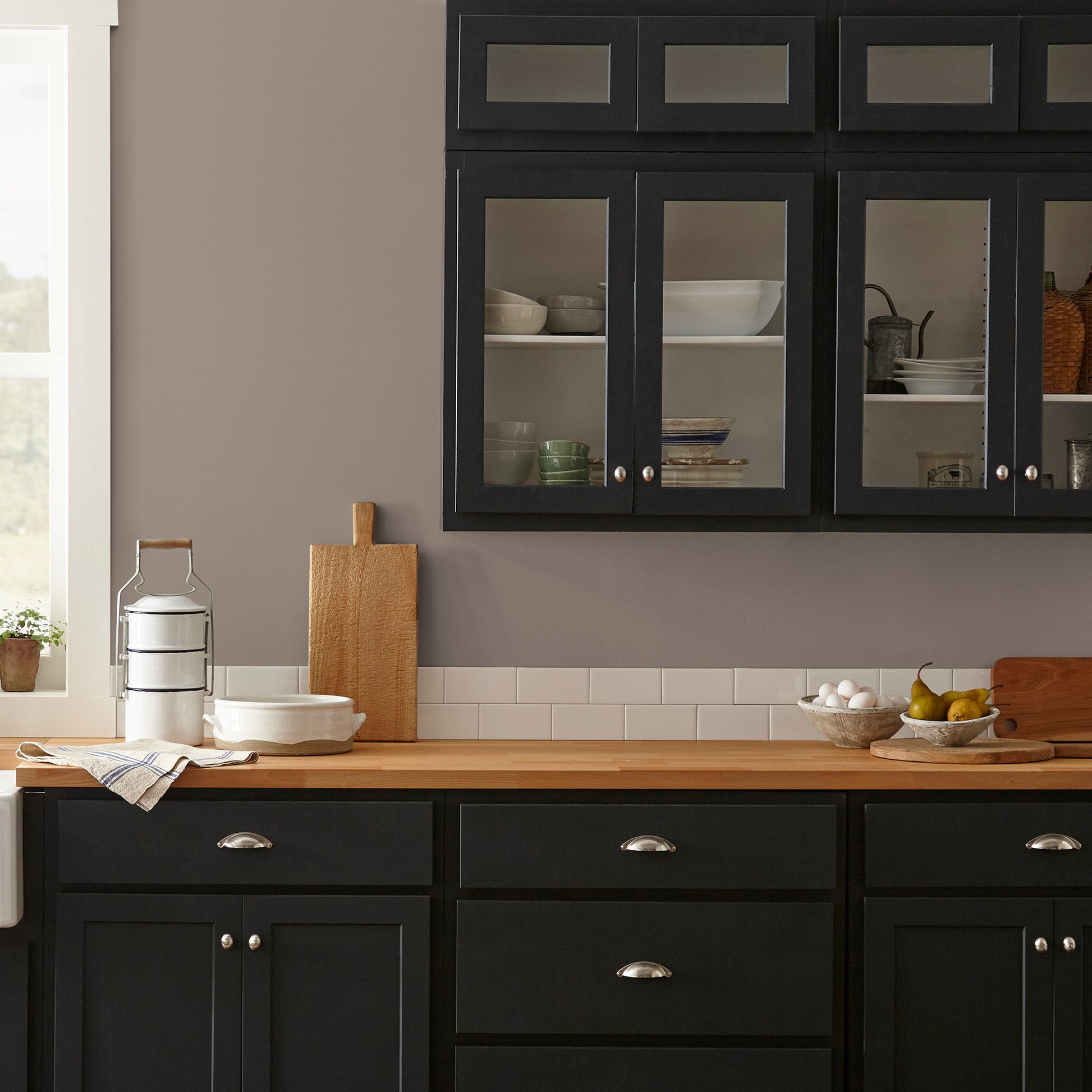 A warm brown with yellow accents interior paint named elemental shown painted on kitchen wall