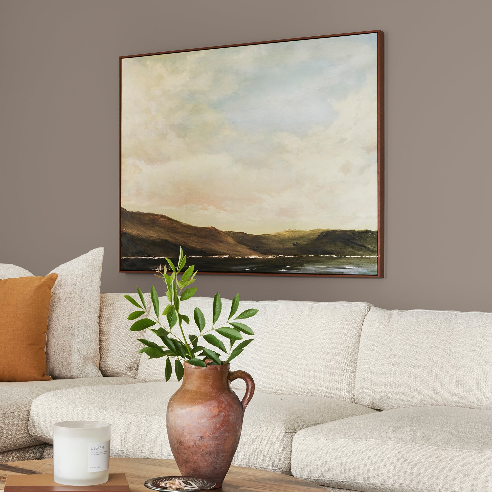 A warm brown with yellow accents interior paint named elemental shown painted on living room wall