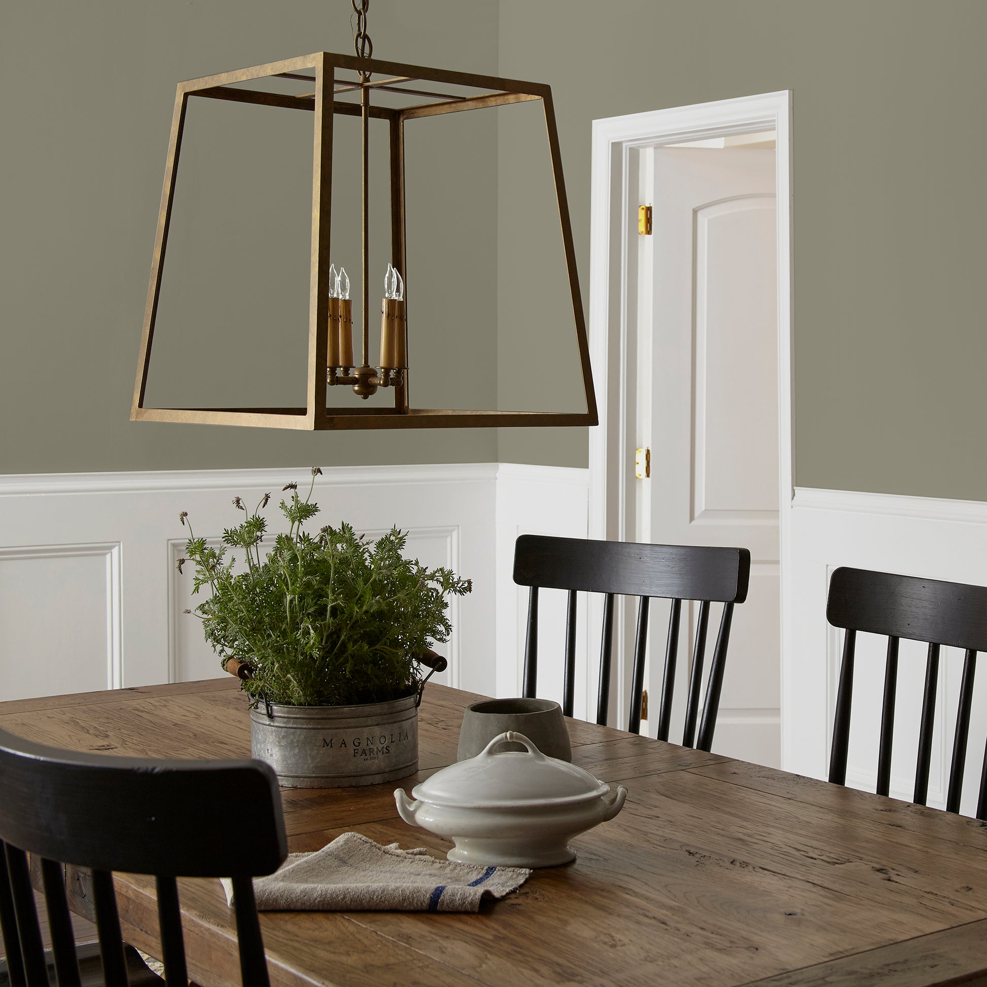 Lighter shade of army green with notes of hazel interior paint named garden party shown painted on dining room wall