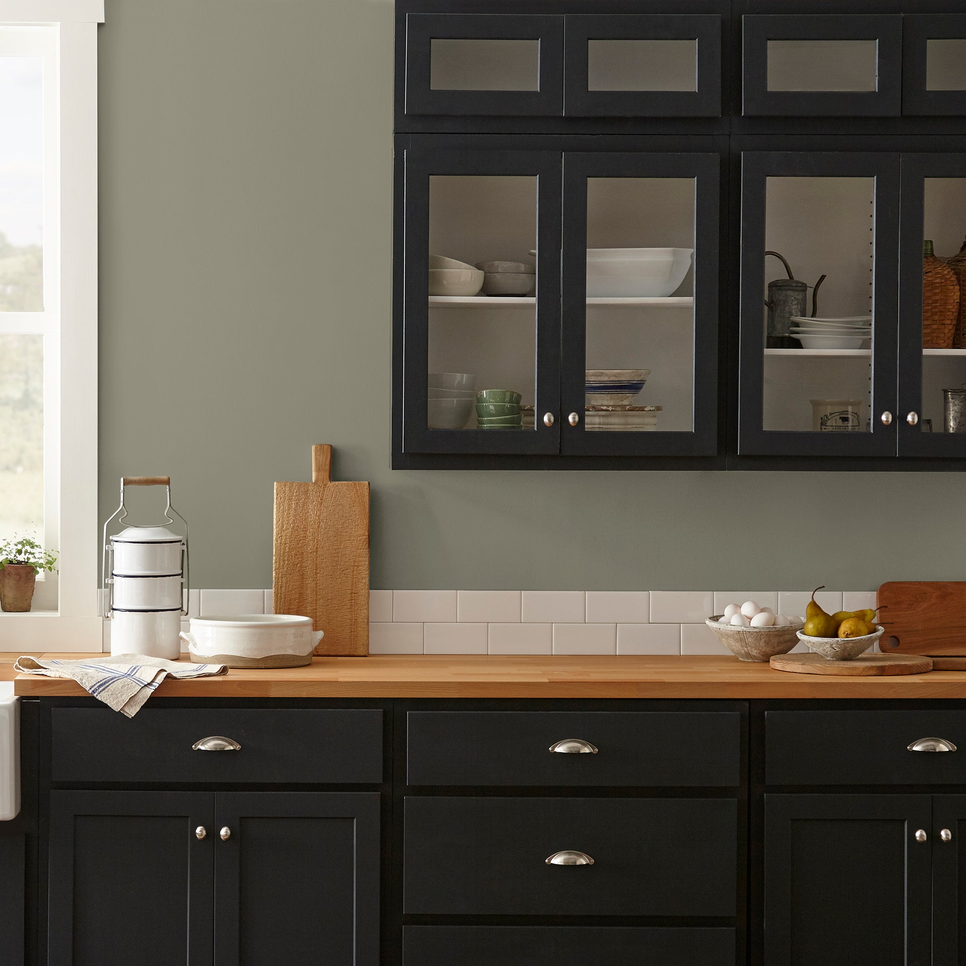 Lighter shade of army green with notes of hazel interior paint named garden party shown painted on kitchen wall