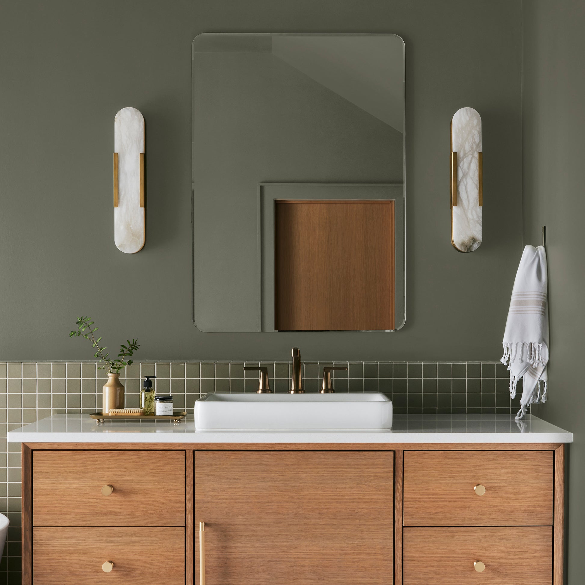A warm olive green interior paint named market place shown painted on bathroom wall