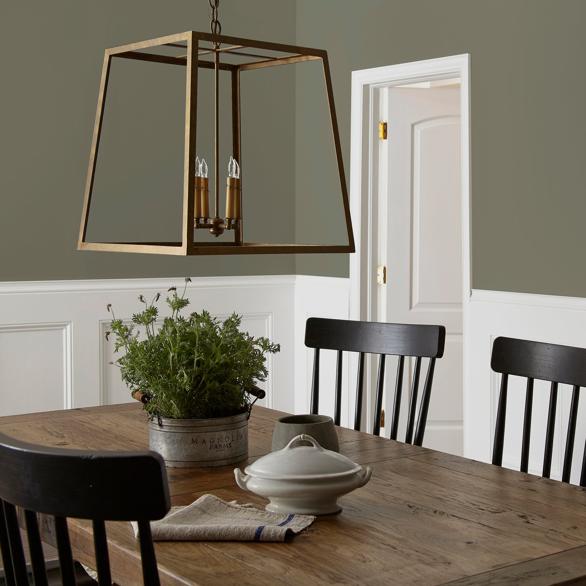 A warm olive green interior paint named market place shown painted on dining room wall