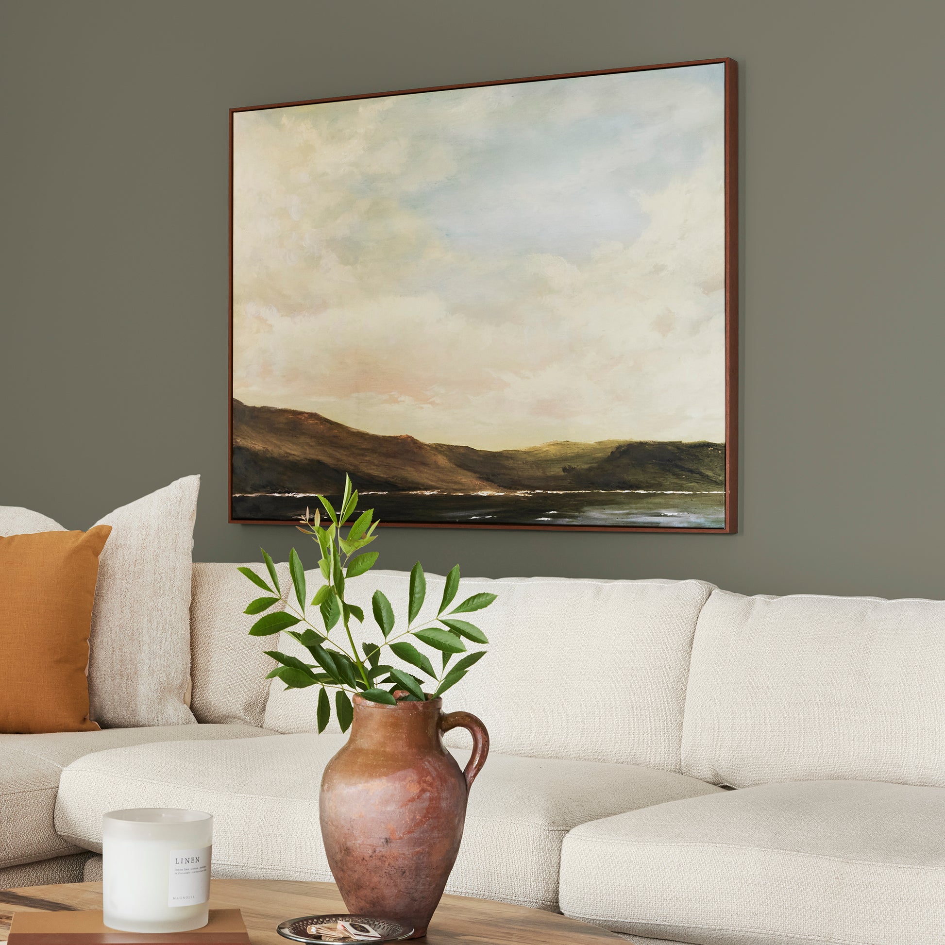 A warm olive green interior paint named market place shown painted on living room wall
