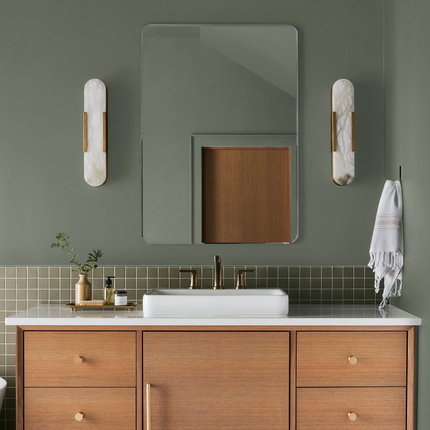 A dusty olive green interior paint named bespoke green shown painted on bathroom wall