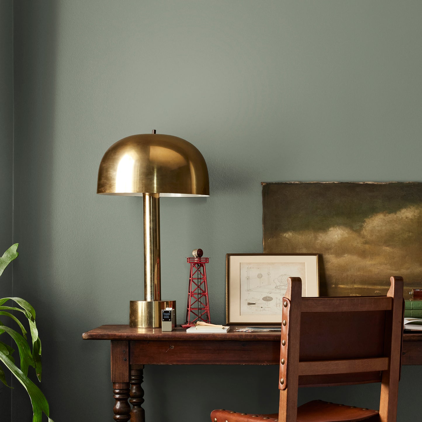 A dusty olive green interior paint named bespoke green shown painted on bedroom wall