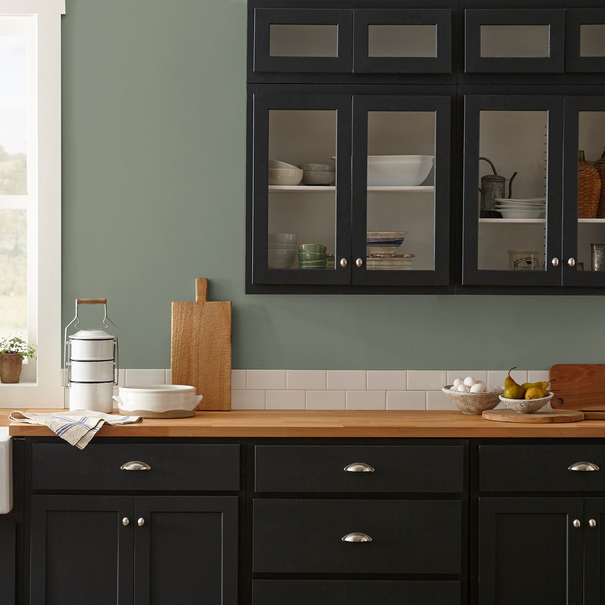 A dusty olive green interior paint named bespoke green shown painted on kitchen wall
