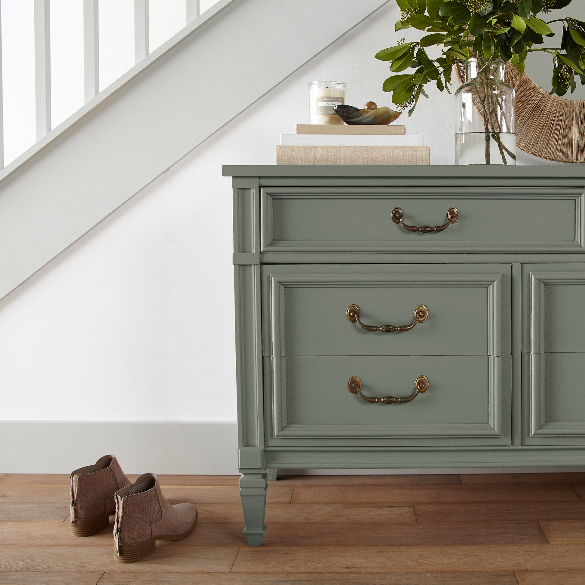 A dusty olive green door and cabinet paint named bespoke green shown painted on entryway cabinet