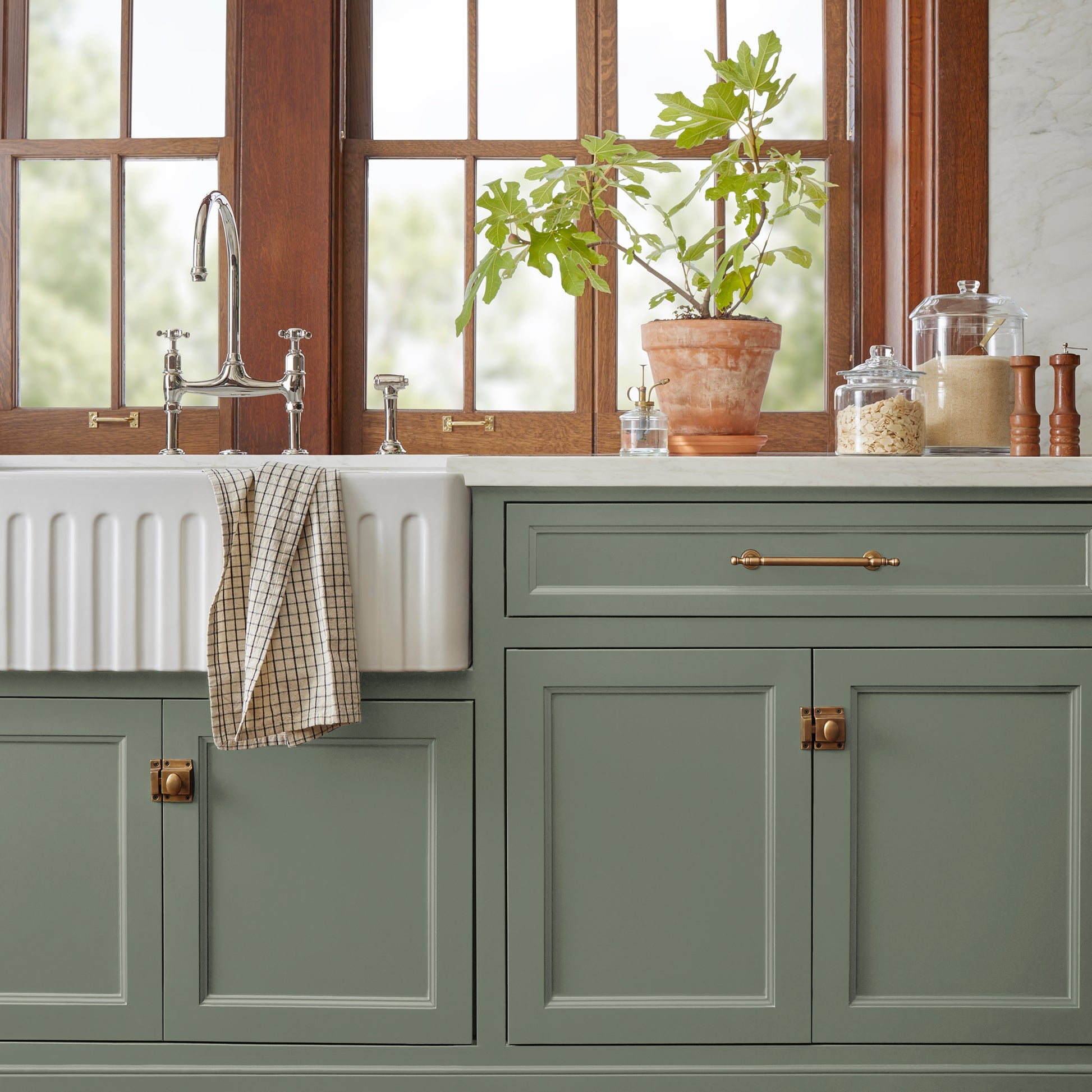A dusty olive green door and cabinet paint name bespoke green shown painted on kitchen cabinet