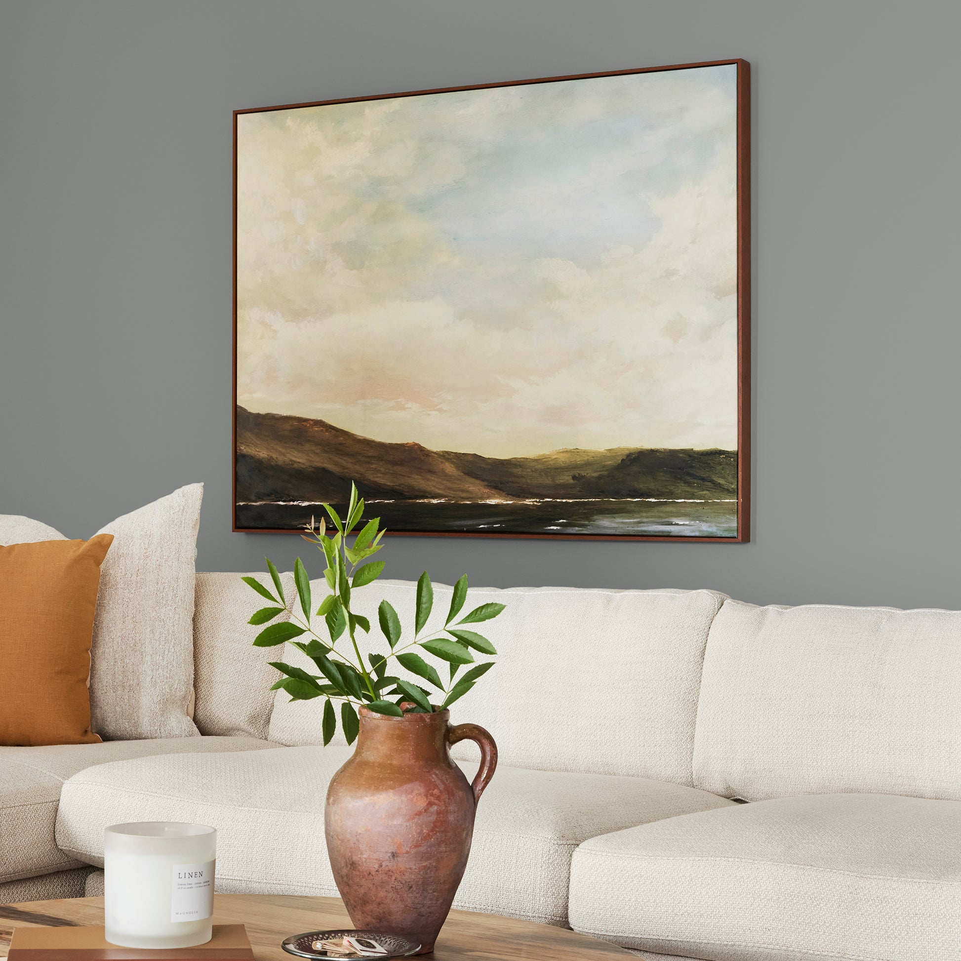 A dark gray with blue and green undertones interior paint named teak cups shown painted on living room wall