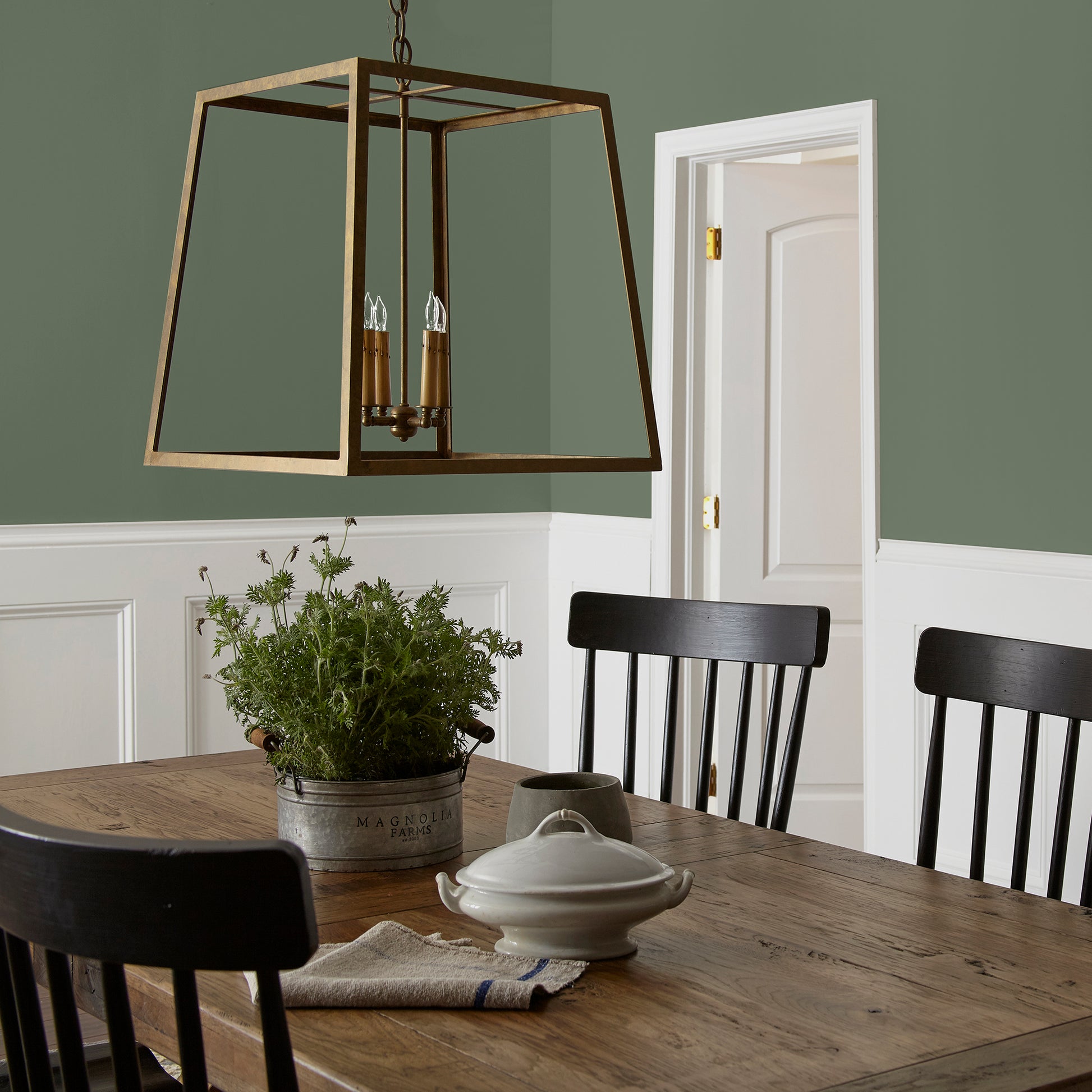 dark sage green paint named lemon leaves shown painted on dining room wall