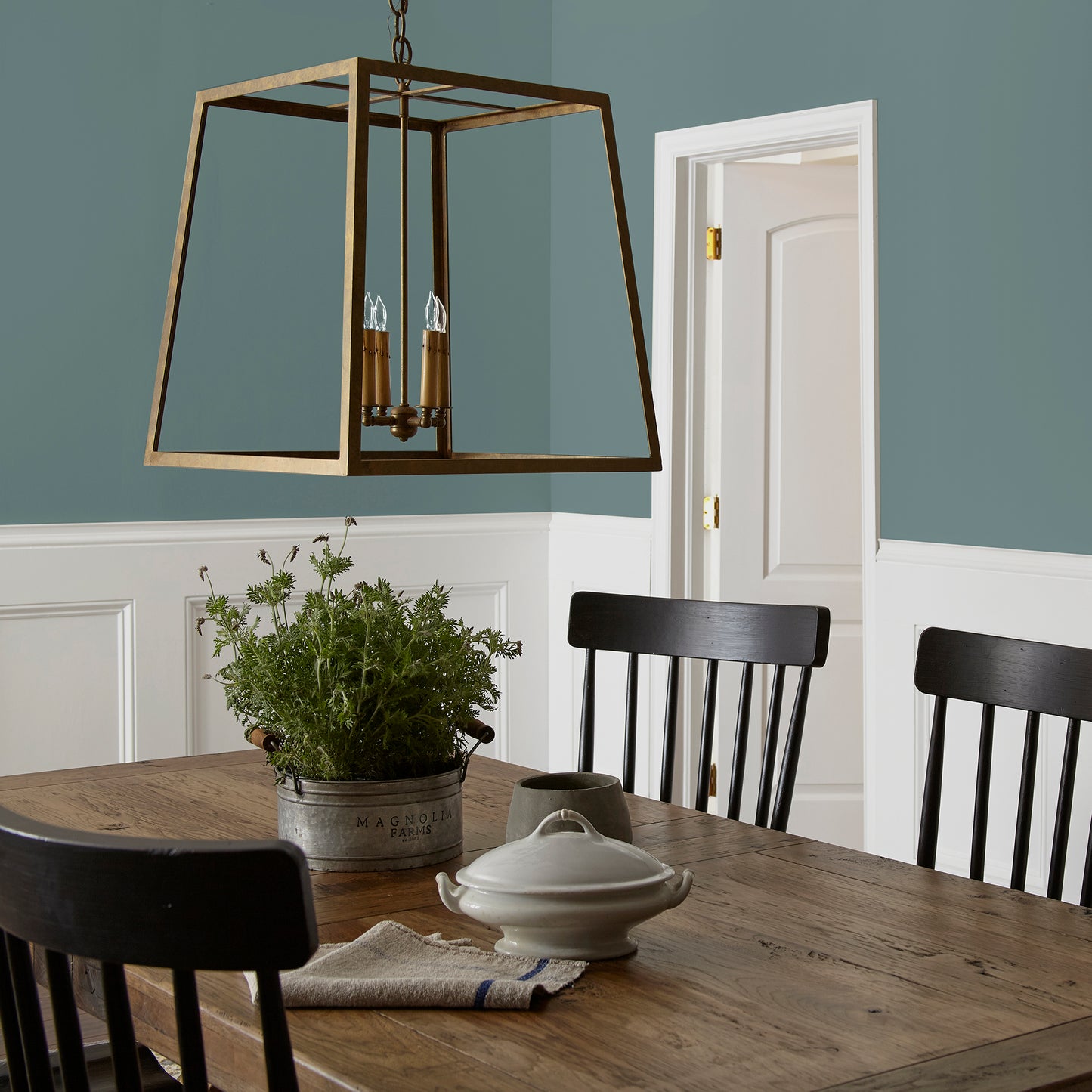 Deep dusty sea green interior paint named demo day shown painted on dining room wall