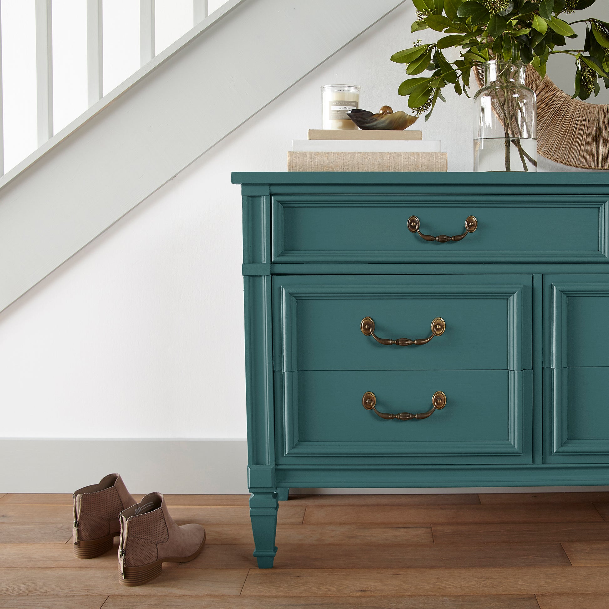 Blue and green combined to create an ashy peacock blue door and cabinet paint named water garden shown painted on entryway cabinet