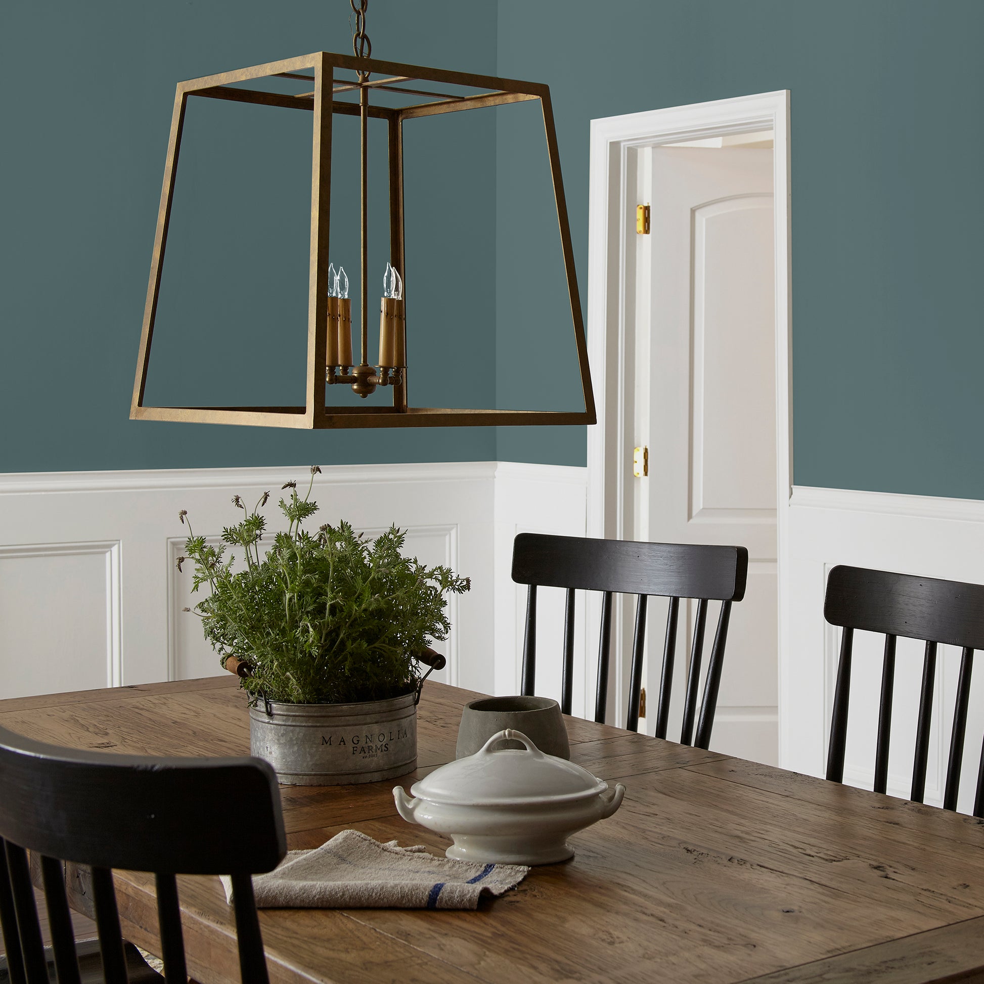 A deep peacock teal blue interior paint named secondhand find shown painted on dining room wall