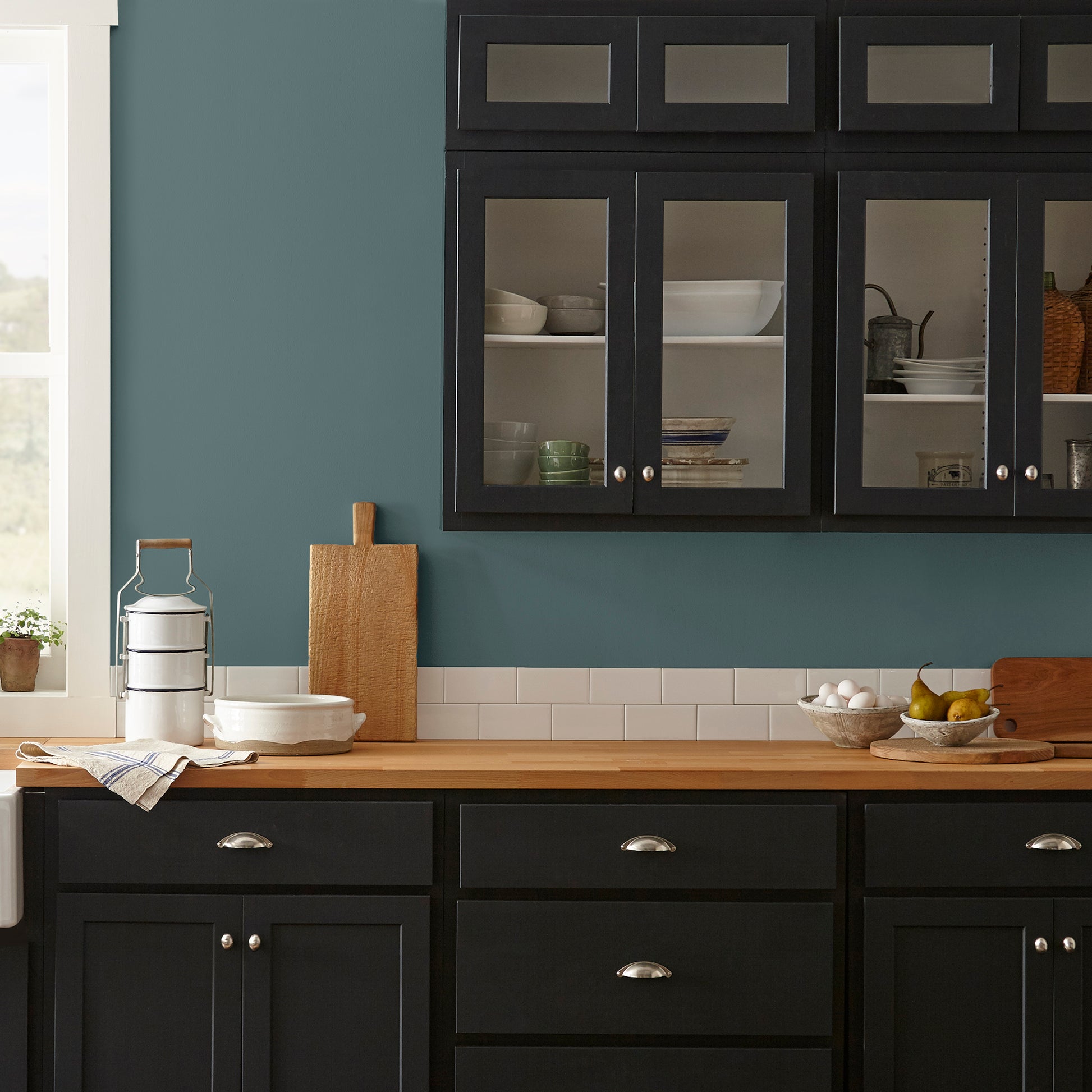 A deep peacock teal blue interior paint named secondhand find shown painted on kitchen wall