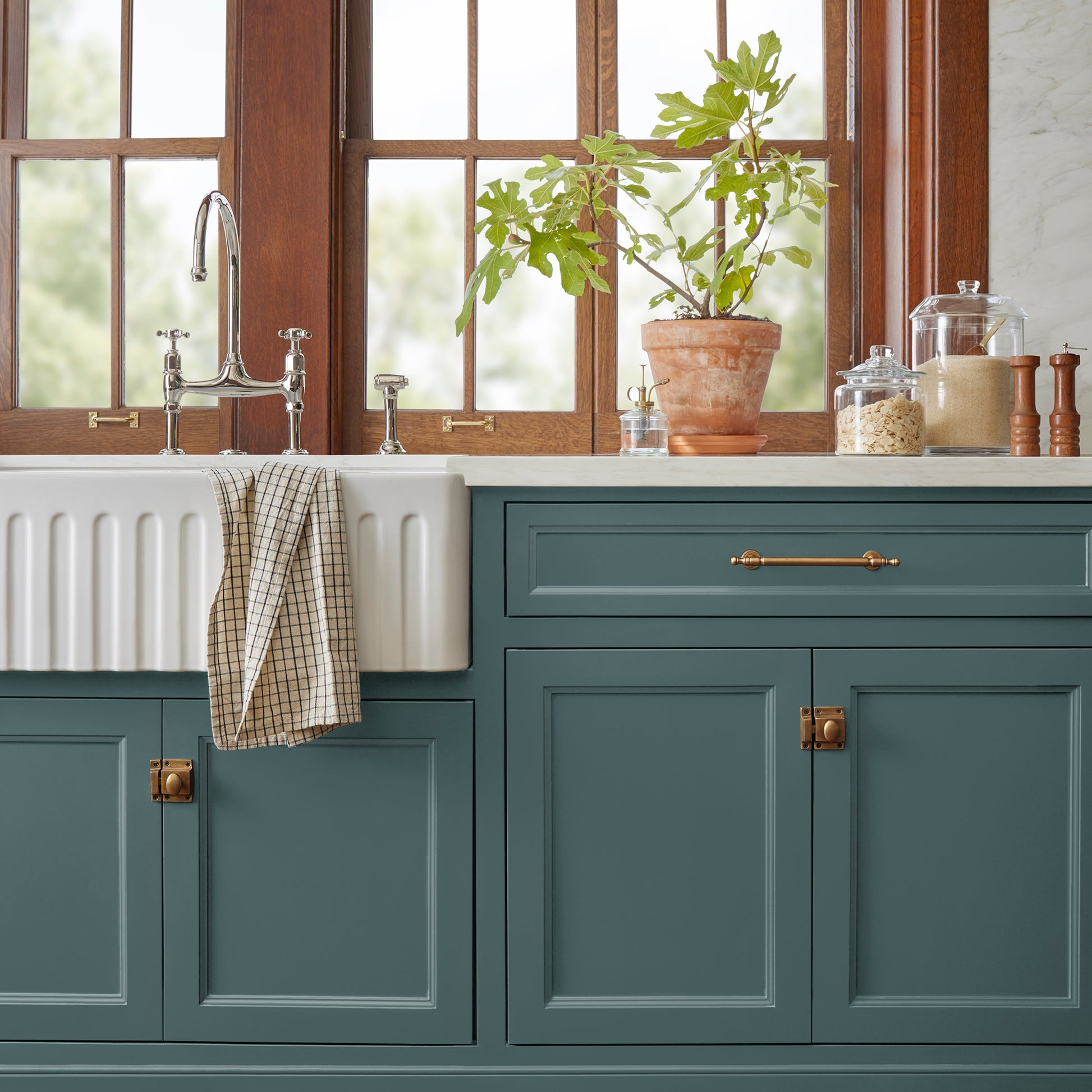 A muted peacock blue door and cabinet paint named secondhand find shown painted on kitchen cabinet