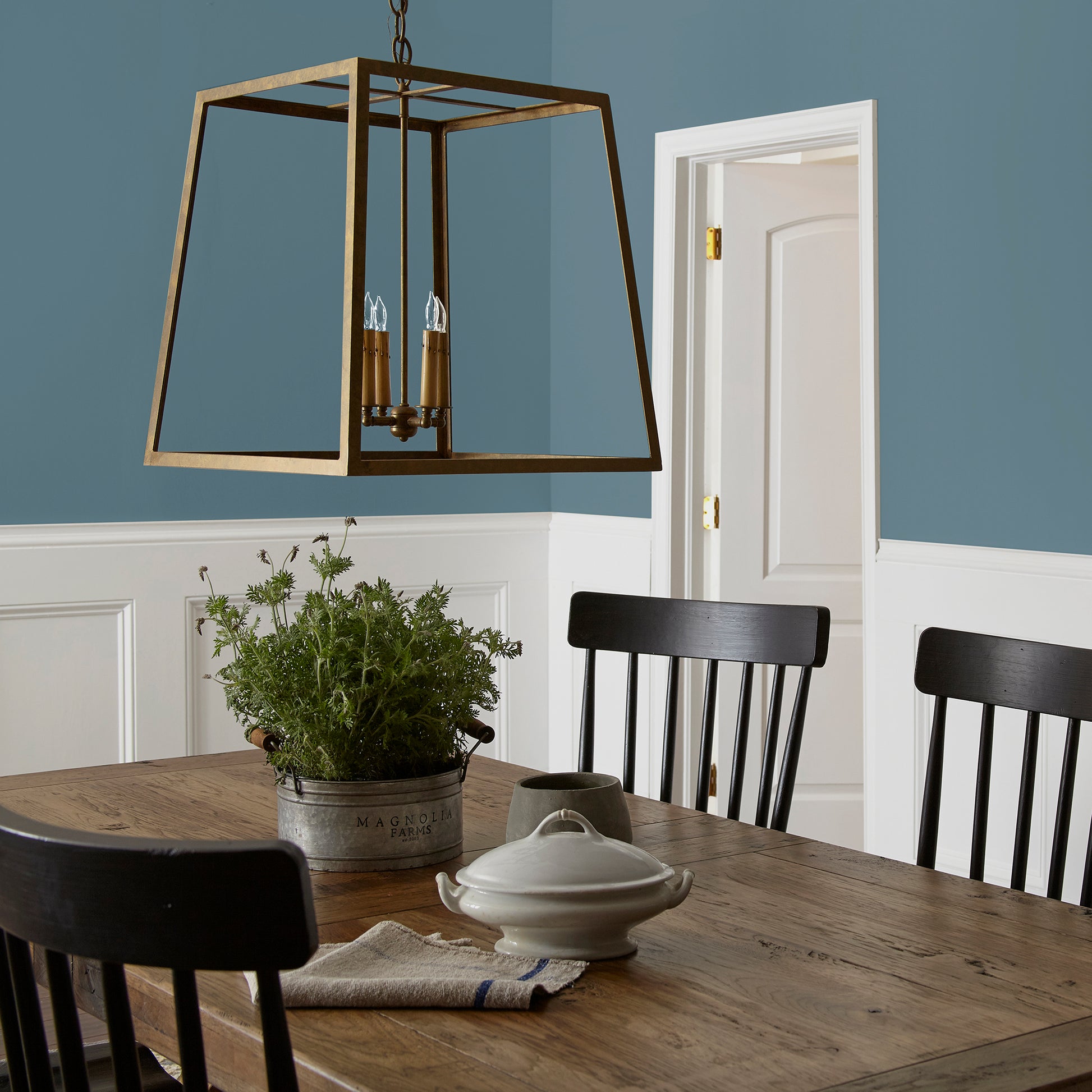 deep steel blue with grey undertone paint named blue skies shown painted on dining room wall