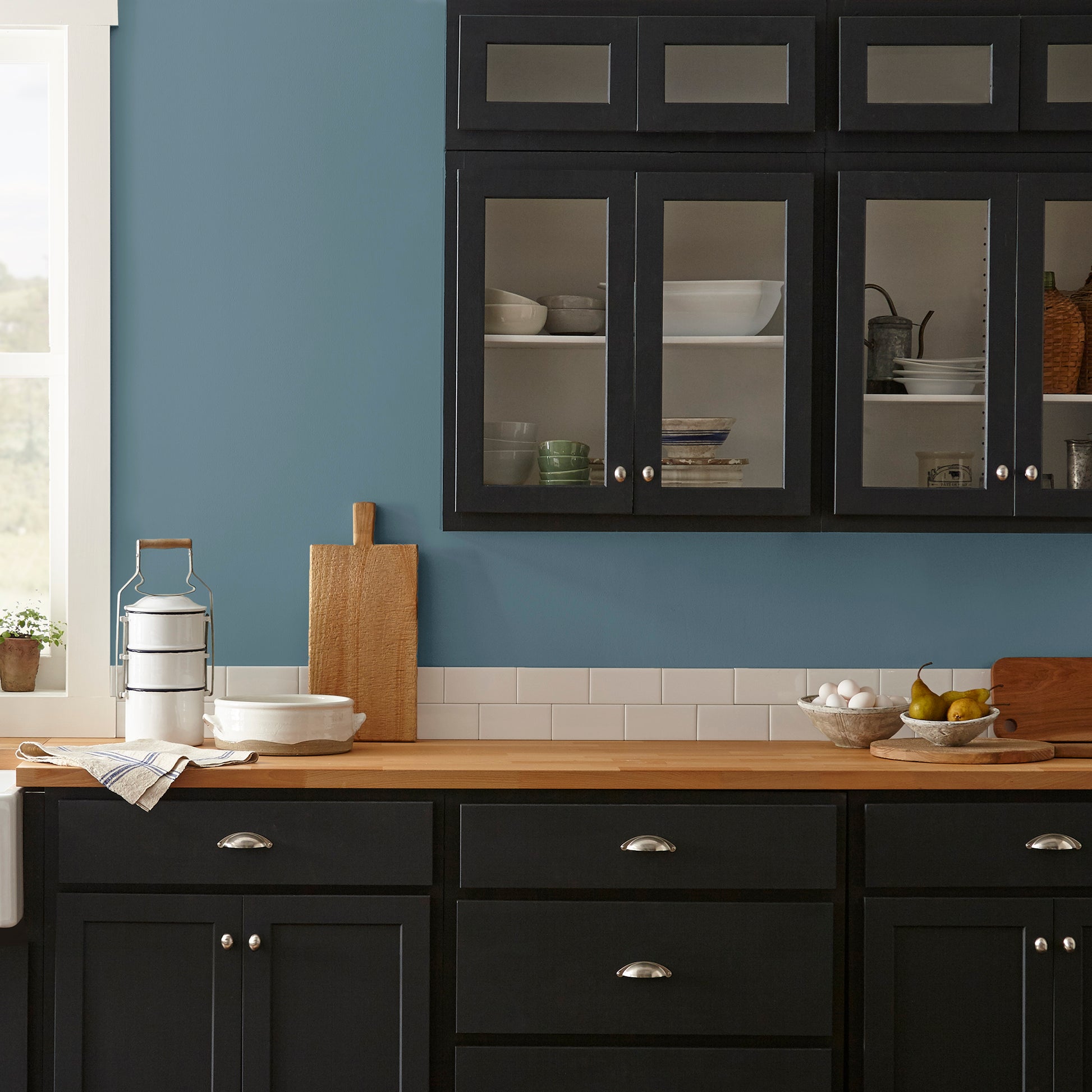 deep steel blue with grey undertone paint named blue skies shown painted on kitchen wall