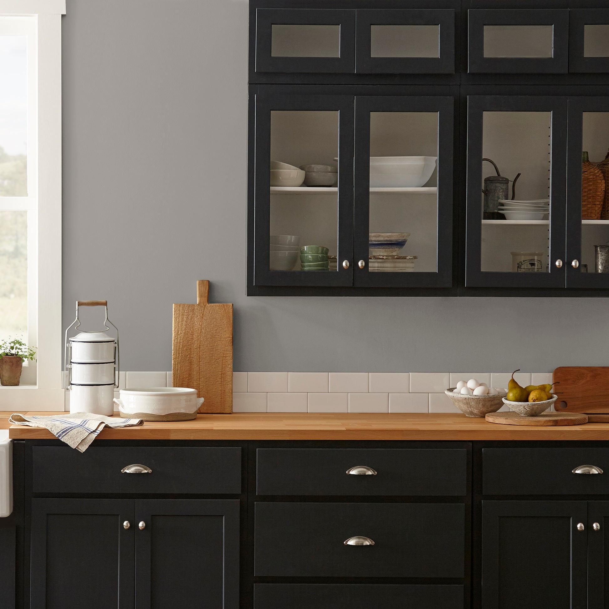 A mousy grayed brown interior paint named before and after shown painted on kitchen wall
