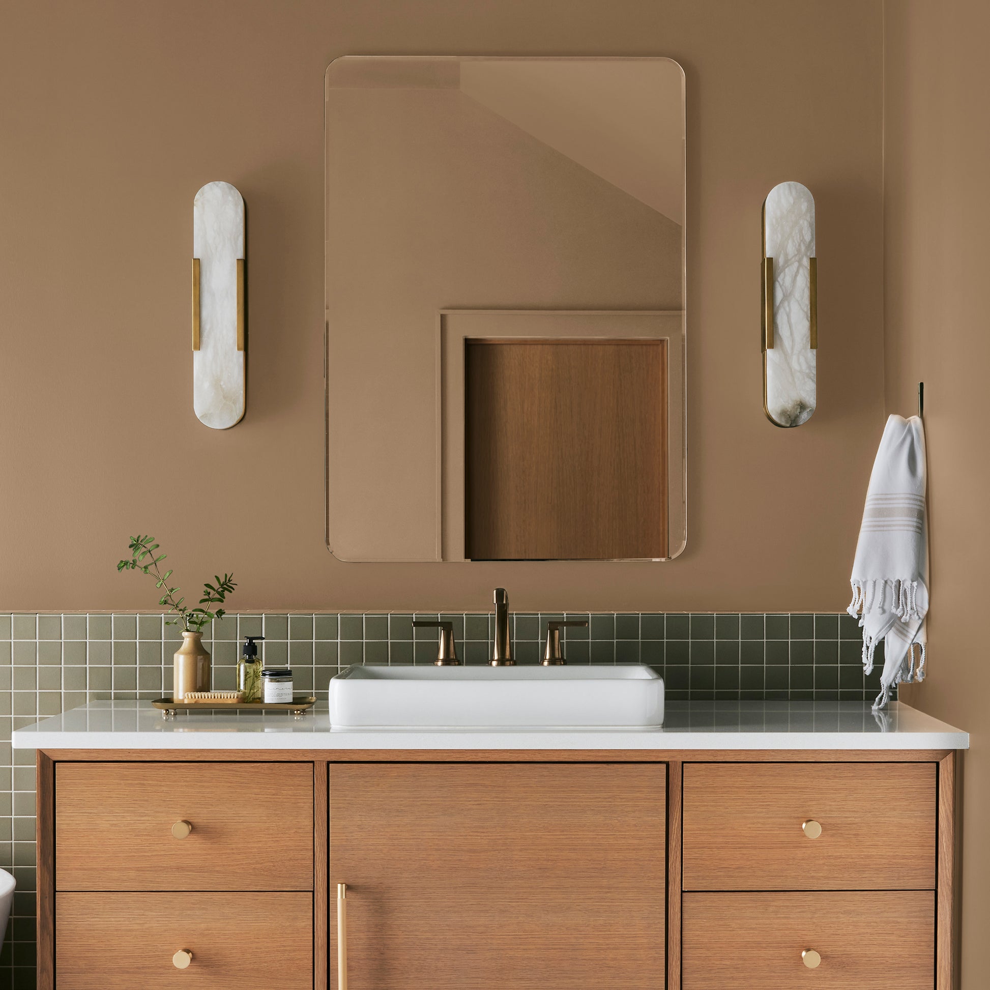 Muted gold interior paint named vintage crown shown painted on bathroom wall