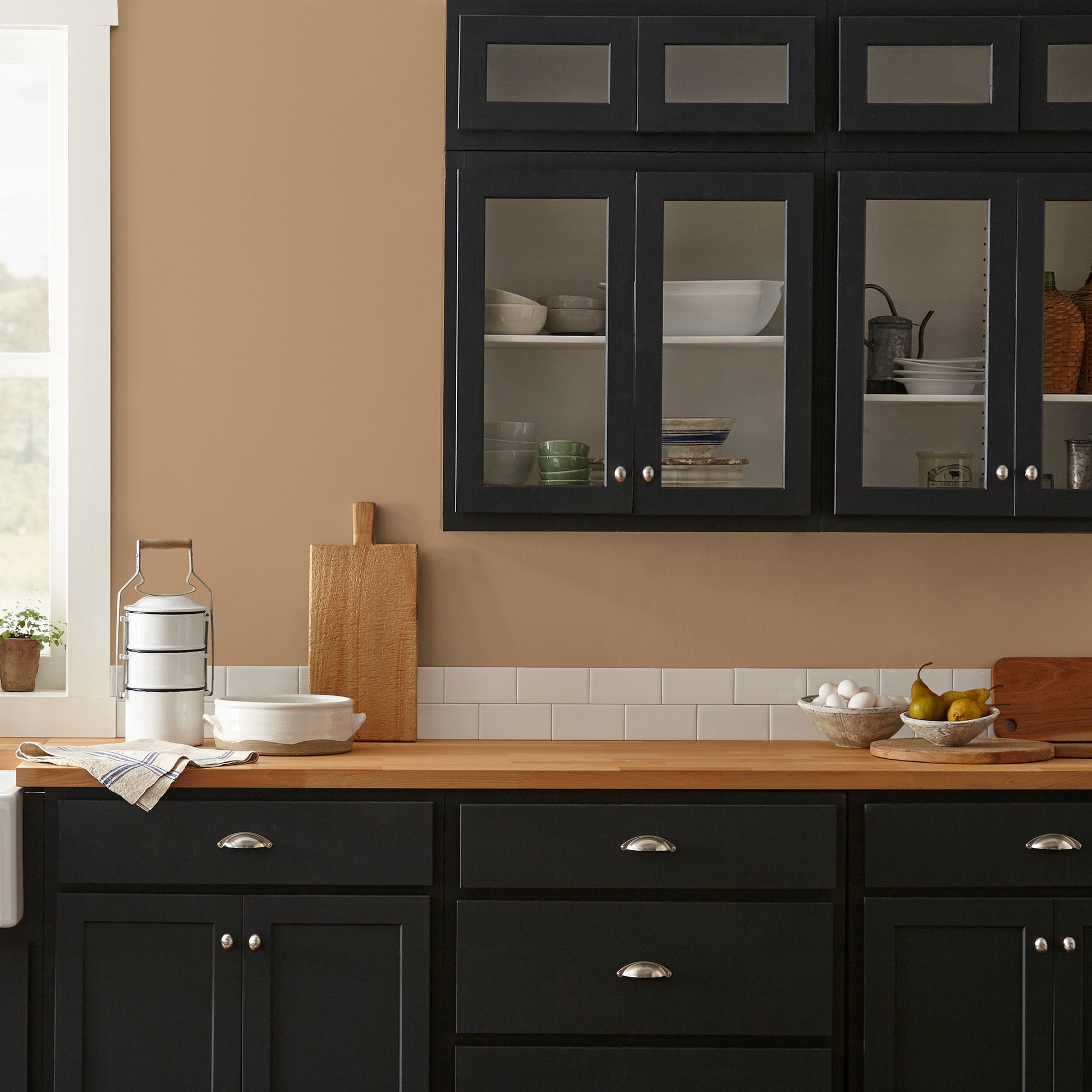 Muted gold interior paint named vintage crown shown painted on kitchen wall