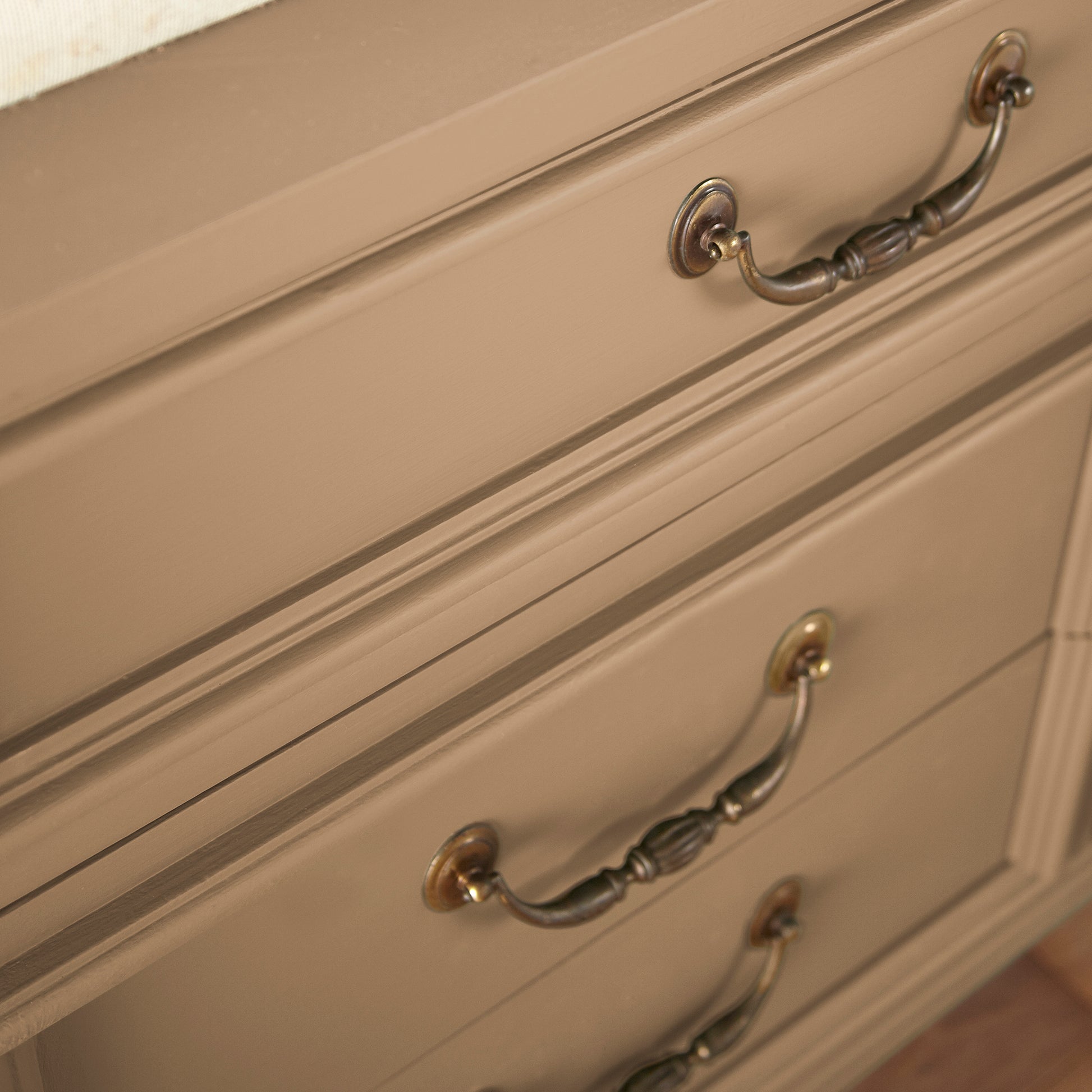 An elegant, muted gold door and cabinet paint named vintage crown shown painted on cabinet