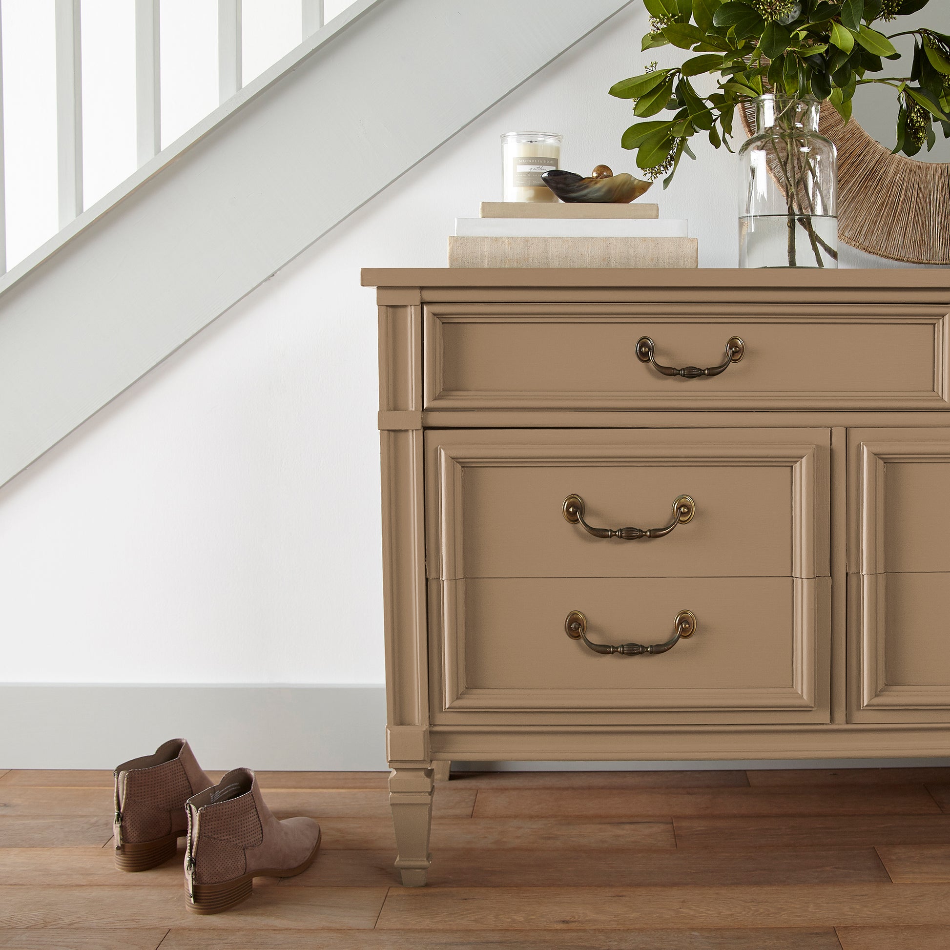 An elegant, muted gold door and cabinet paint named vintage crown shown painted on entryway cabinet