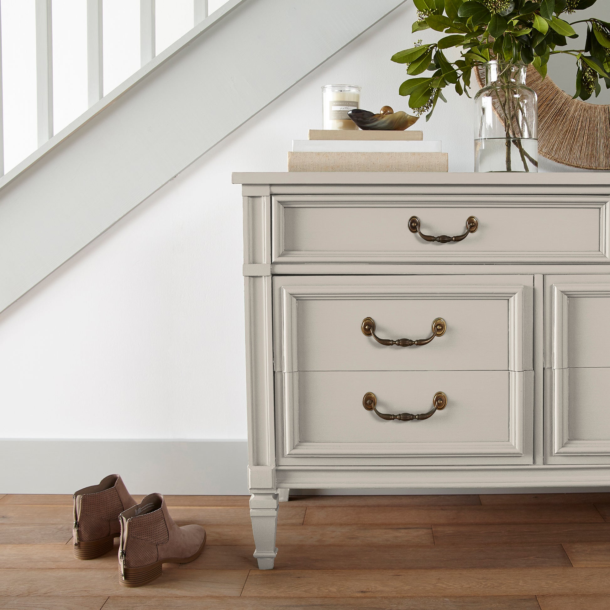 A creamy, soft white with a timeless essence door and cabinet paint named castle cream shown painted on entryway cabinet