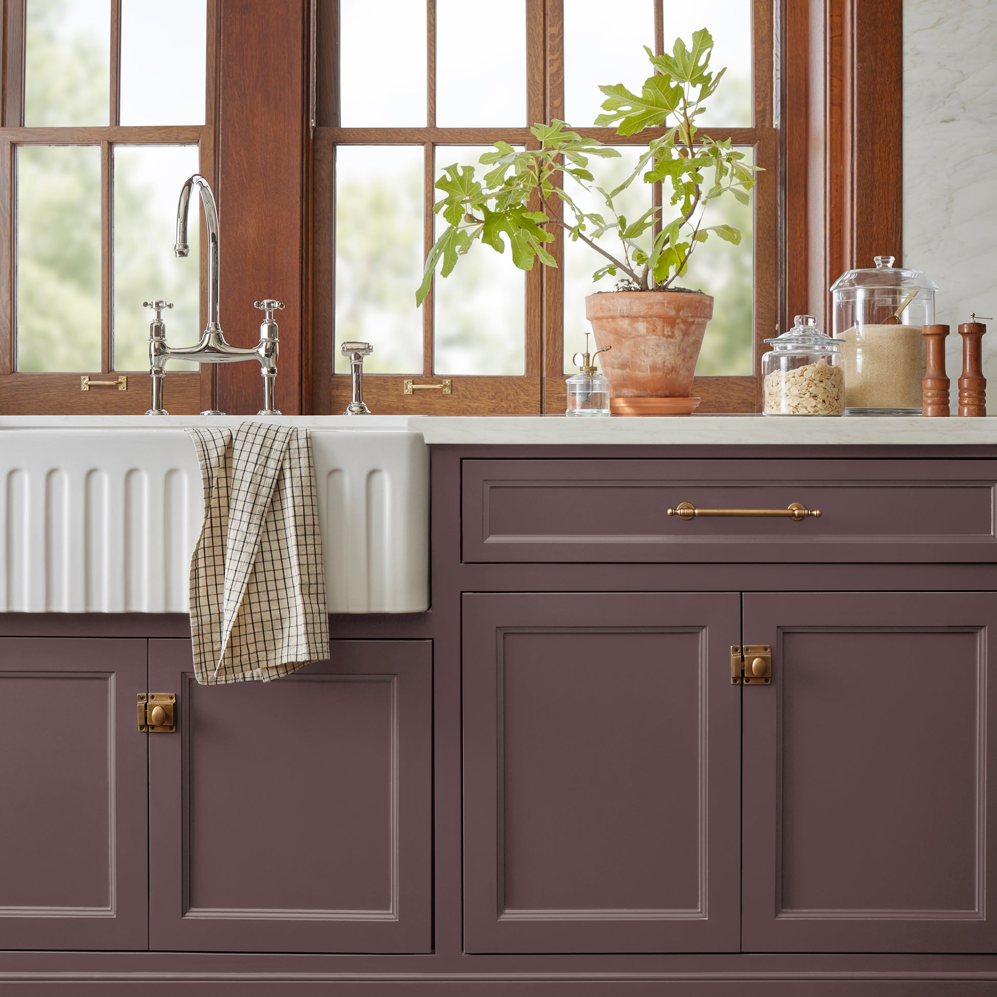 A beautifully saturated burgundy door and cabinet paint named moody fig shown painted on kitchen cabinet