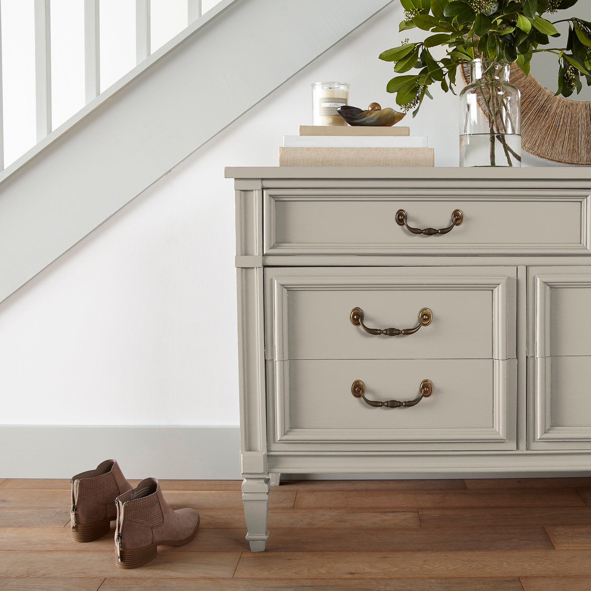A light beige with a warm, soothing tone door and cabinet paint named plaster shown painted on entryway cabinet