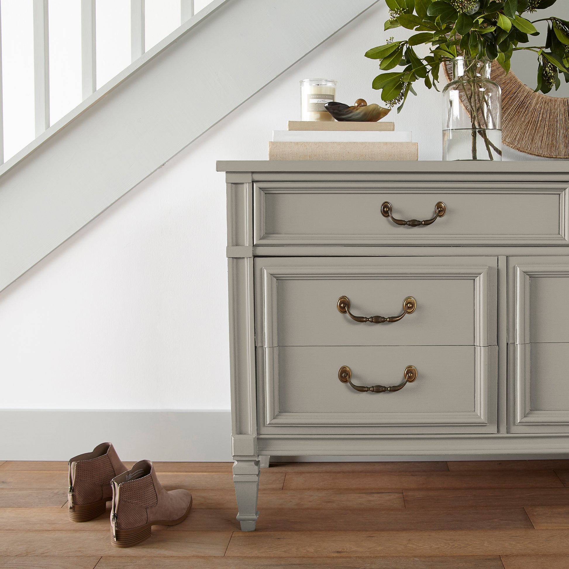 A soft French gray door and cabinet paint named drawing room shown painted on entryway cabinet