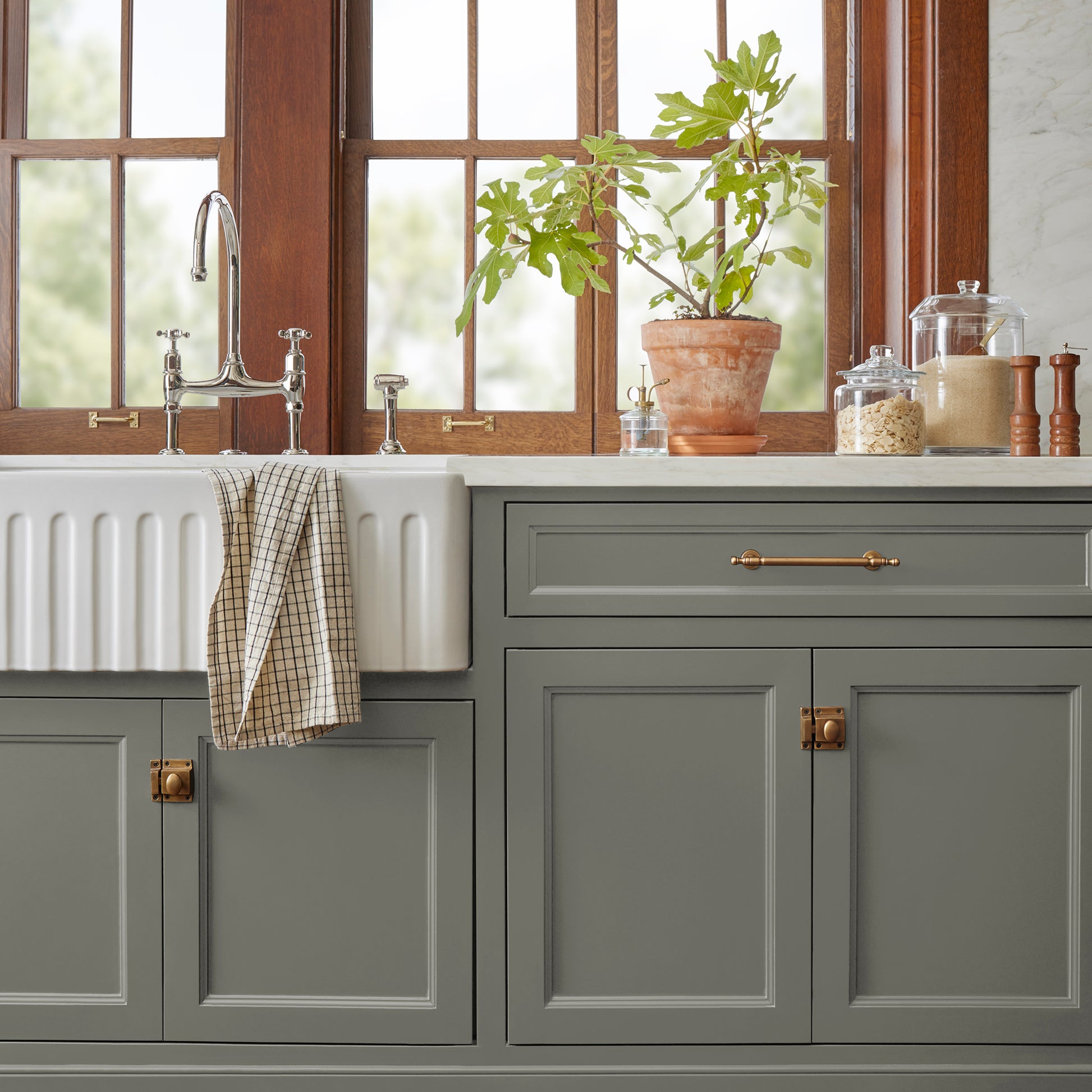 A deep sage with a soft gray undertone door and cabinet paint named estate shown painted on kitchen cabinet