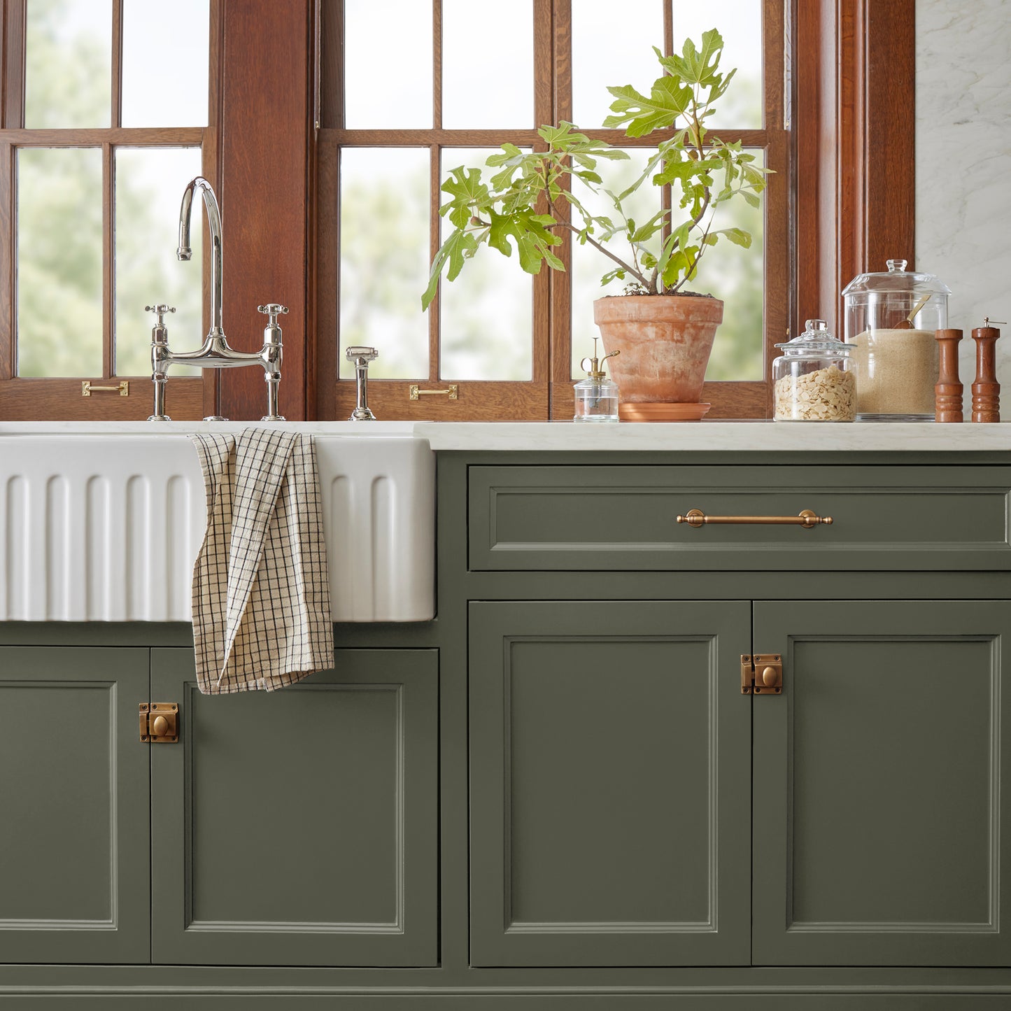 A lively, deep olive door and cabinet paint named step stool green shown painted on kitchen cabinet