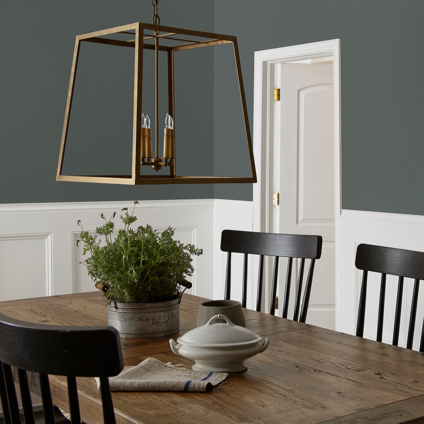 moody navy infused with deep green interior paint named cottage grove shown painted on dining room wall