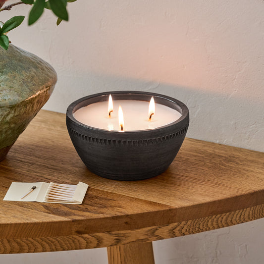 Magnolia Gathered Rustic Bowl Candle shown burning on table