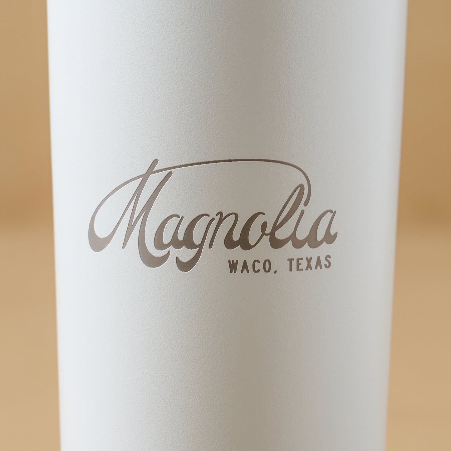 Magnolia White 24oz Cold Tumbler with Straw close up of magnolia logo on cup