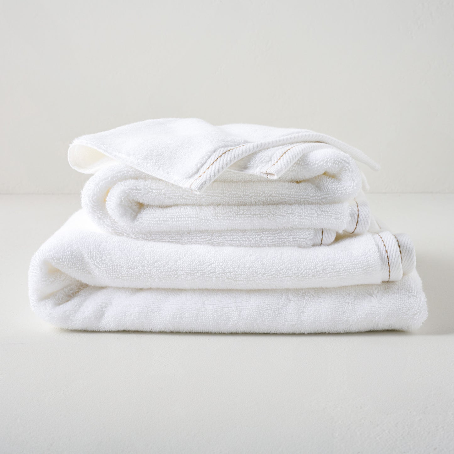 Magnolia White Plush Stitched Edge Towels shown stacked