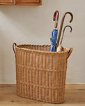 Natural Rattan Console Basket filled with umbrellas in a room