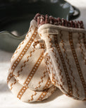 Natural Embroidered Stripe Oven Mitt Set of 2 close up on top of scalloped baker