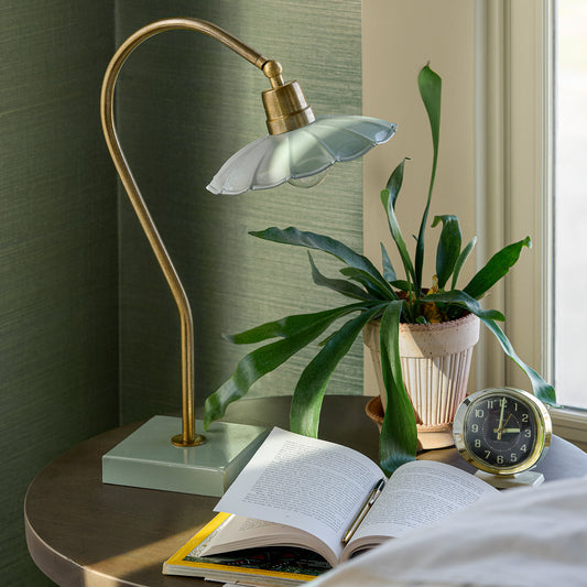 Lamp in seafoam on a nightstand with a plant